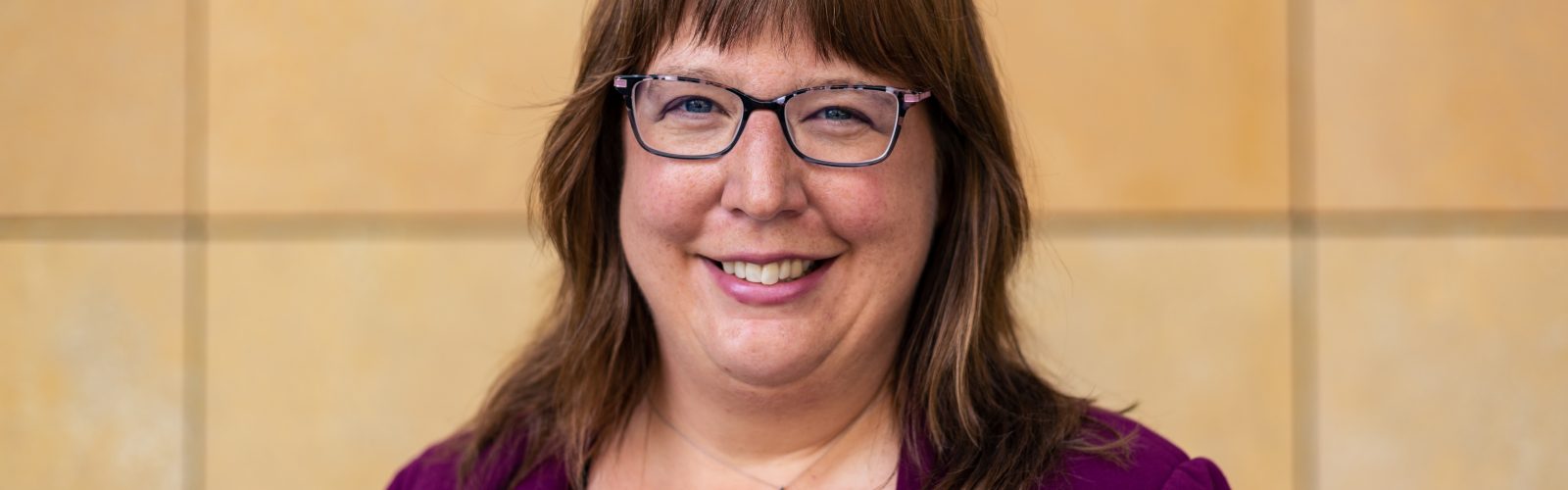 person with glasses, smiling